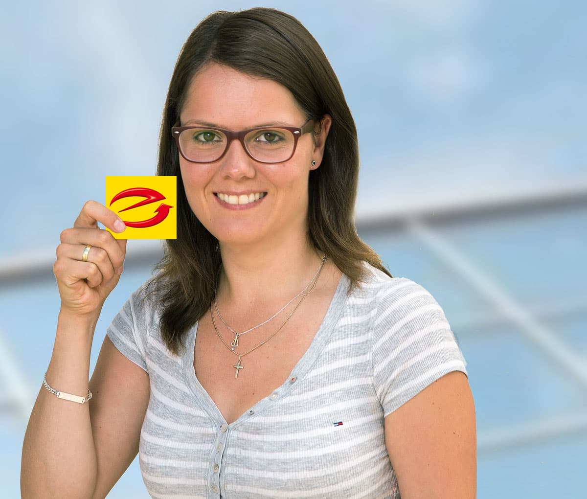 Eine Mitarbeiterin hält das Logo des E-Checks in der Hand.