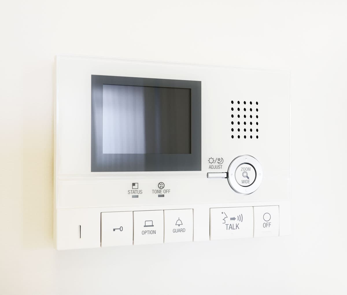 Video-Sprechanlage mit Bildschirm und Bedientasten an einer Wand.